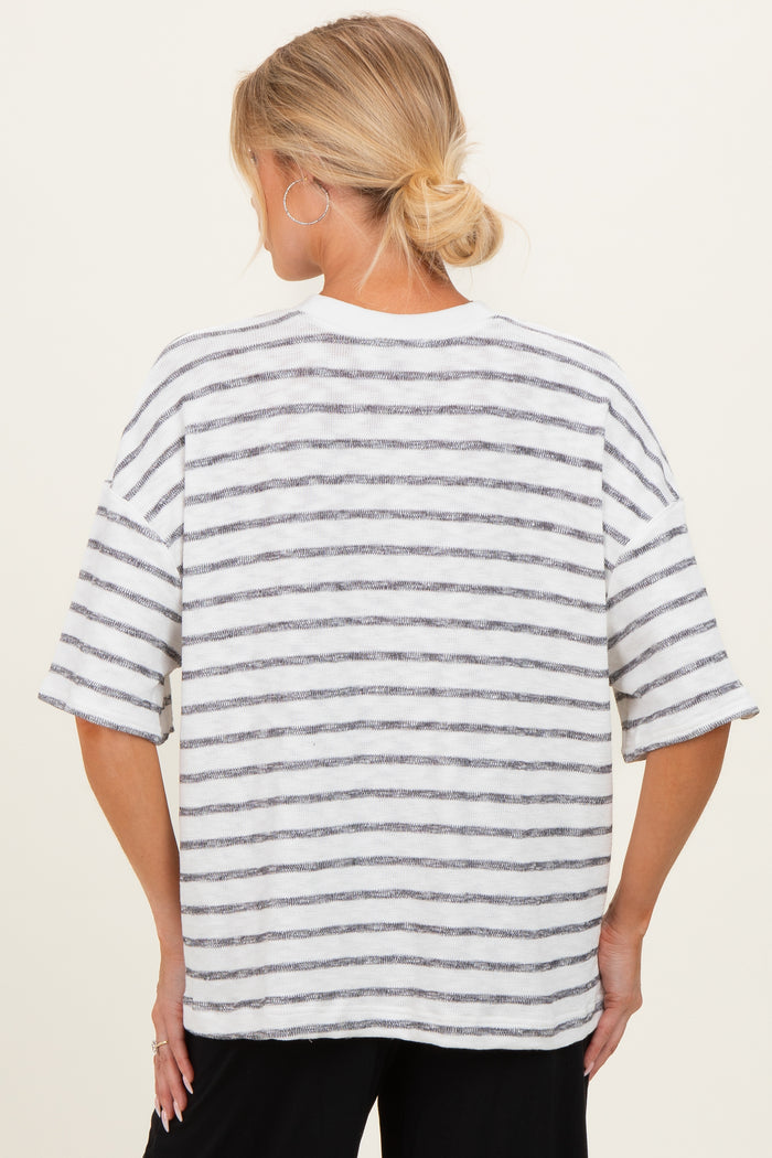 woman wearing a striped gray and white oversized maternity top, view from the back