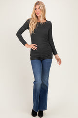 woman wearing a dark gray long sleeve top paired with flared denim jeans