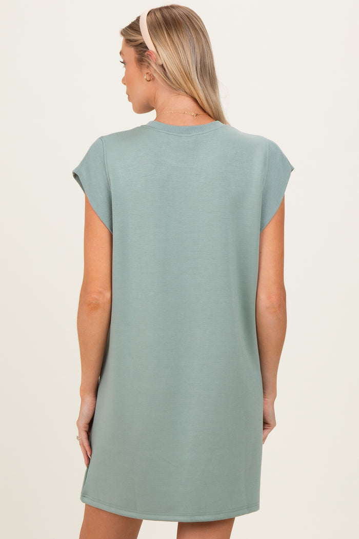 woman wearing a light green short sleeve maternity dress, view from the back