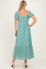woman wearing a light teal lace maxi dress with puff sleeves, shown from the back