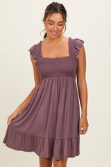 woman wearing a mauve short sundress with ruffled straps and a smocked bodice