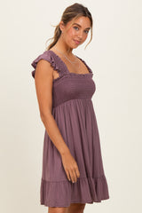 woman wearing a mauve smocked mini dress with ruffled sleeves and a tiered hem