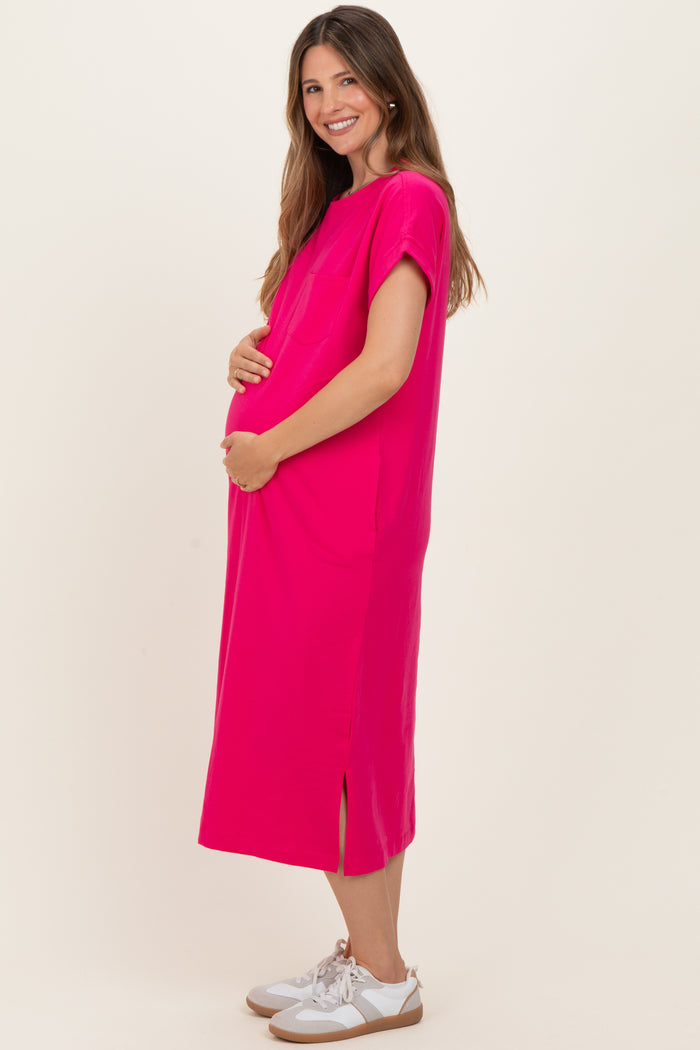 woman wearing a bright pink maternity dress with short sleeves and side slits, holding her baby bump
