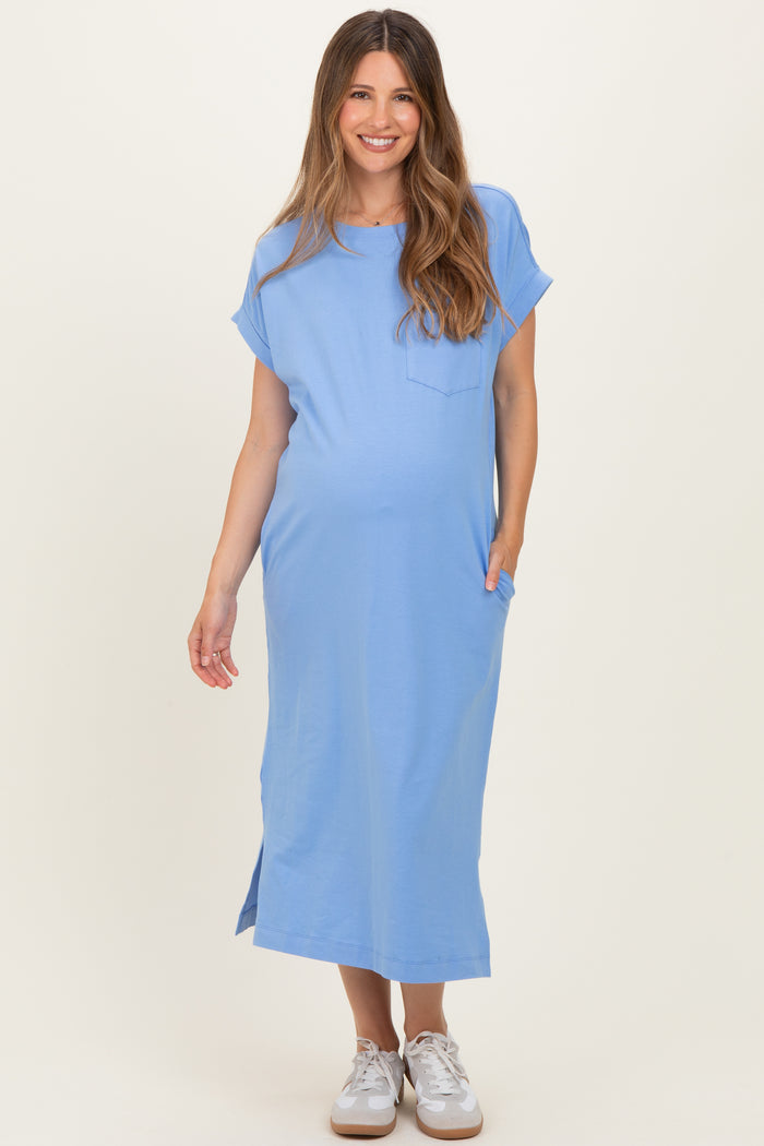 woman wearing a light blue maternity dress with short sleeves and pockets, displaying her baby bump