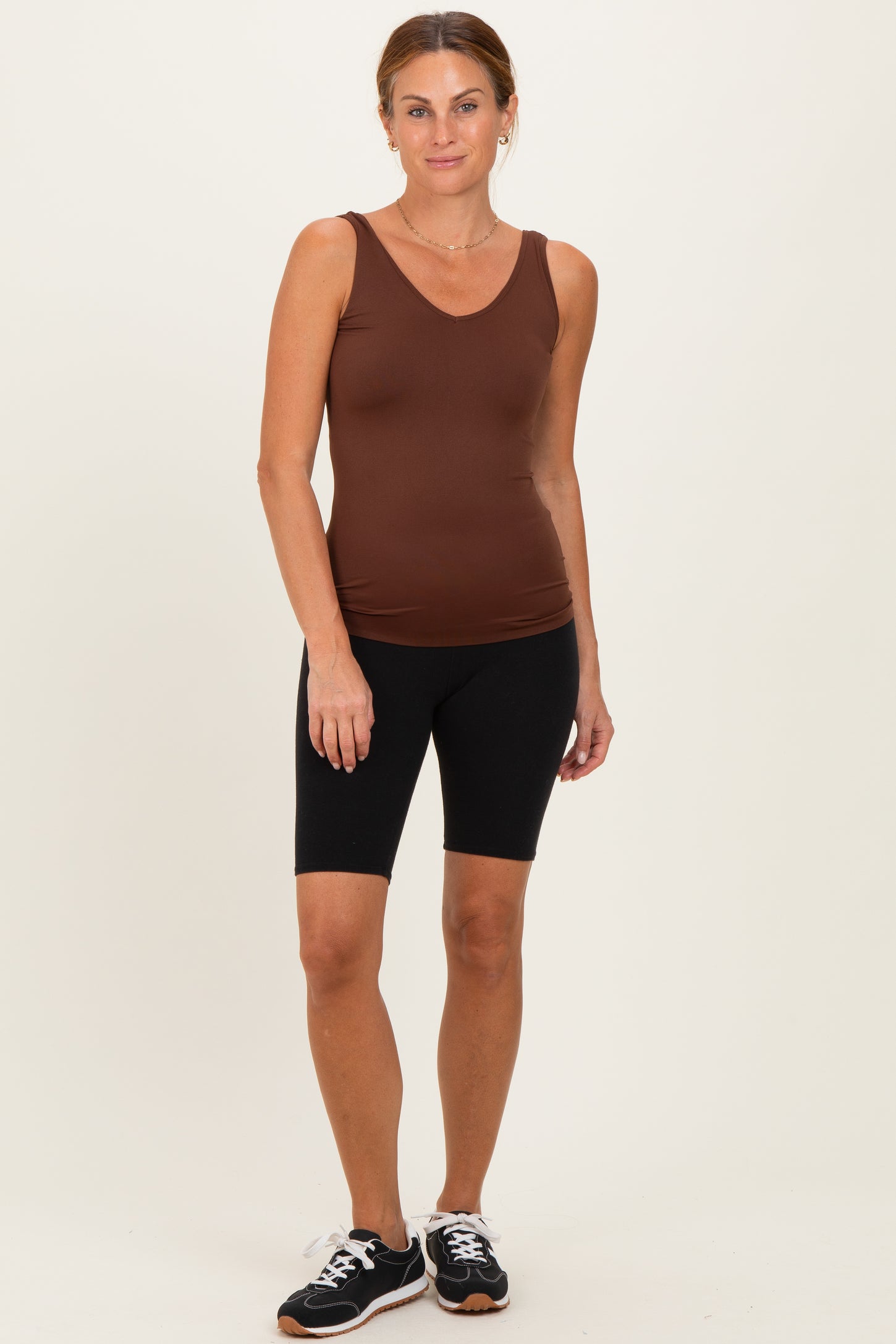 woman wearing a brown sleeveless v-neck tank top and black bike shorts
