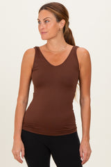 woman wearing a brown sleeveless v-neck tank top paired with black leggings