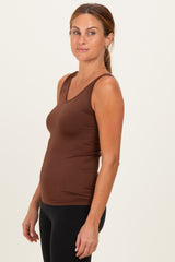 woman wearing a brown fitted tank top with a v-neck and black leggings