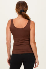 woman wearing a brown sleeveless fitted tank top with a scoop neckline and black leggings, seen from the back