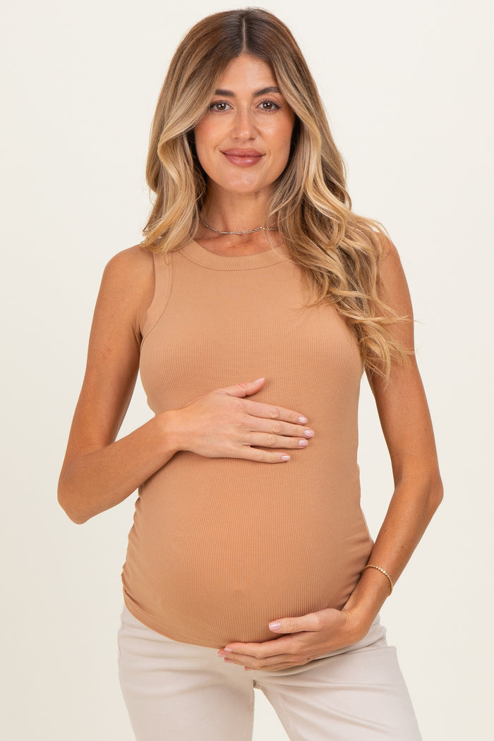 woman wearing a tan ribbed maternity tank top and holding her baby bump