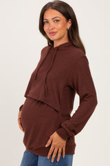 woman wearing a brown maternity hoodie with a cropped design and a visible baby bump
