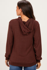 woman wearing a brown maternity hoodie, showing the back view with a hood and ribbed cuffs