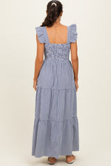 woman wearing a navy and white gingham maxi dress with ruffled sleeves and tiered skirt, seen from the back