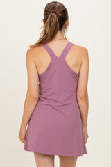 woman wearing a lavender maternity dress with a racerback style and a flared skirt, showing her back