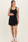 woman wearing a black maternity dress with a slight side slit and holding her baby bump