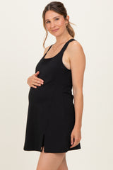 woman wearing a black maternity tank dress, showing her baby bump with a side slit detail