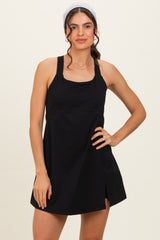 woman wearing a black sleeveless mini dress with a square neckline and side slit, styled with a headband
