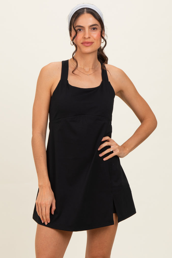 woman wearing a black sleeveless mini dress with a square neckline and side slit, styled with a headband