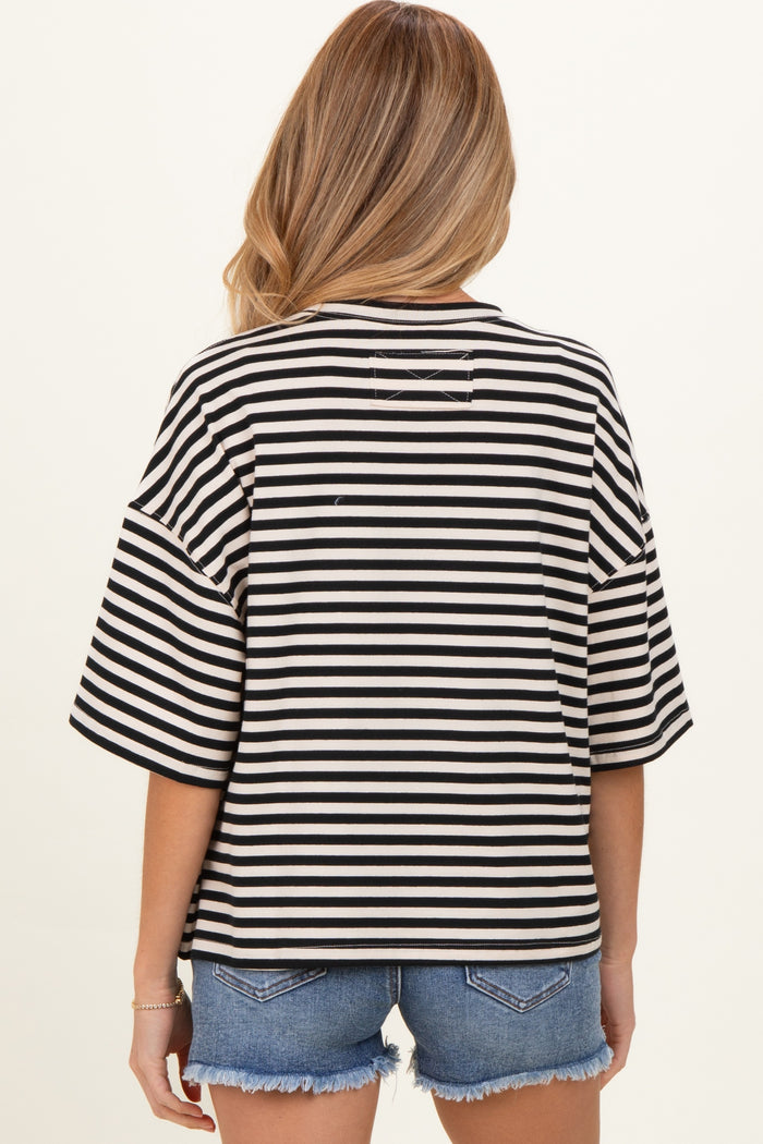 woman wearing a black and white striped oversized maternity top with short sleeves and back detail