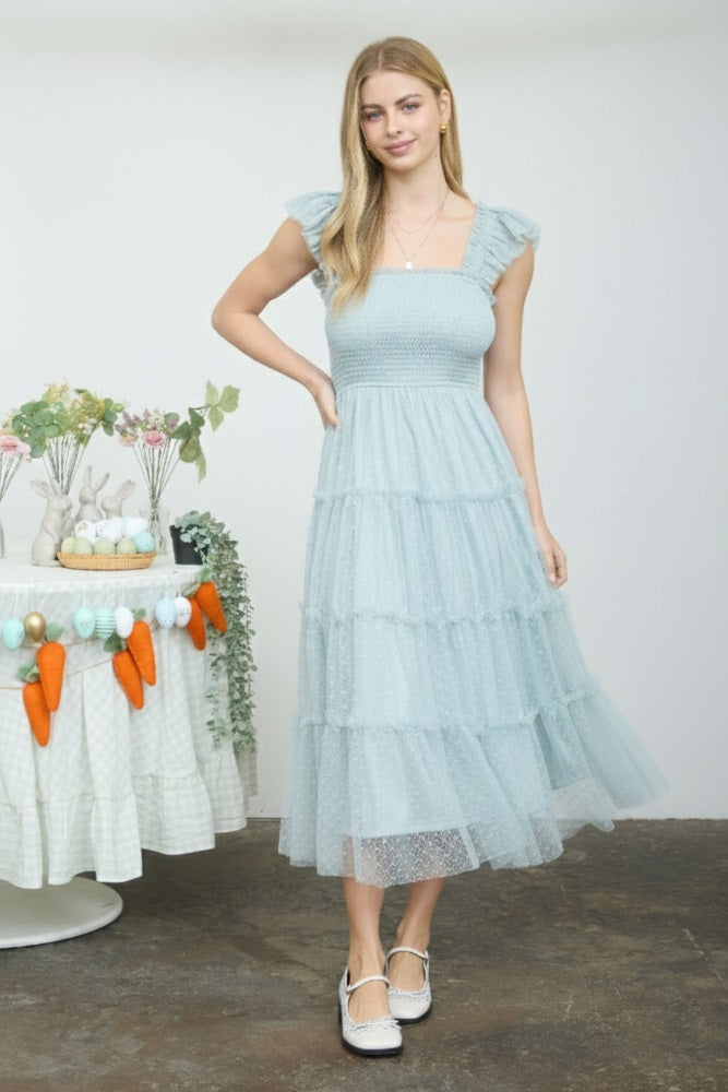 woman wearing a light blue tiered midi dress with ruffle sleeves and a smocked bodice