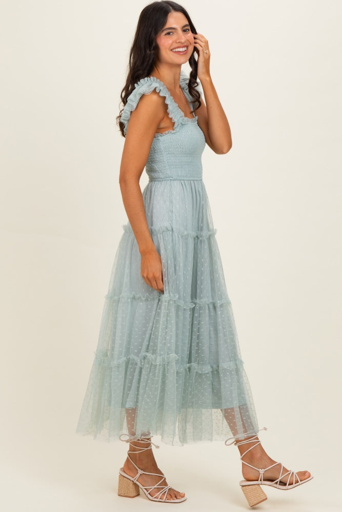 woman wearing a light blue tiered maxi dress with ruffled straps and polka dots, styled with strappy block-heeled sandals