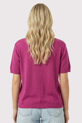 woman wearing a short sleeve fuchsia sweater viewed from the back with wavy blonde hair