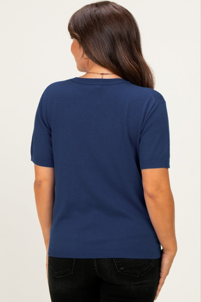 woman wearing a navy blue short sleeve maternity top, shown from the back