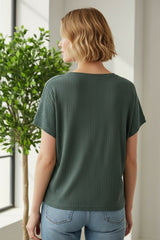 woman wearing a dark green ribbed short sleeve top, seen from the back, paired with light blue jeans