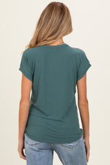 woman wearing a green ribbed maternity top, view from the back, paired with light blue jeans