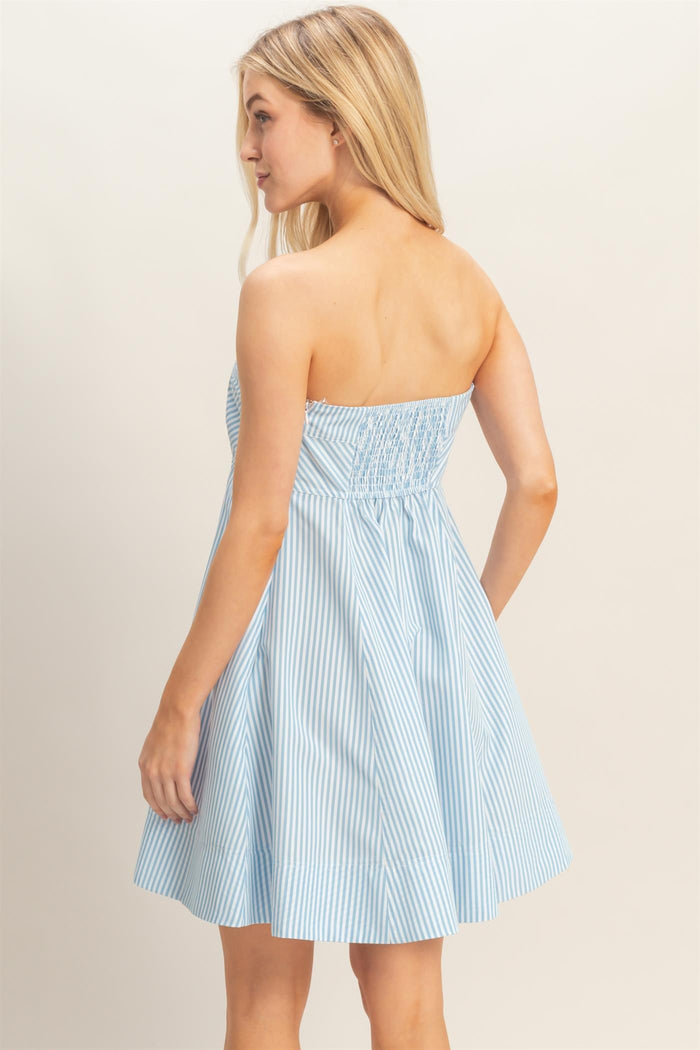 woman wearing a blue and white striped strapless sundress with a fitted bodice and flared skirt