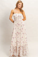 woman wearing a white floral maxi dress with a smocked bodice and adjustable straps
