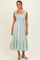 woman wearing a mint green midi dress with floral stripes and tie shoulder straps, styled with simple sandals
