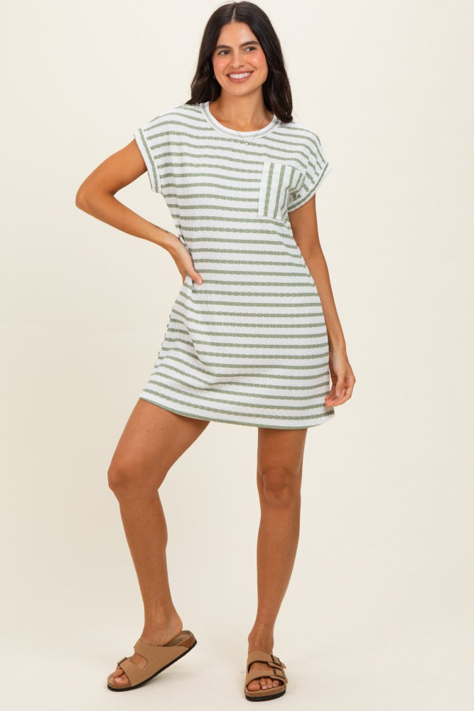 woman wearing a green and white striped short sleeve dress with a front pocket and side pockets