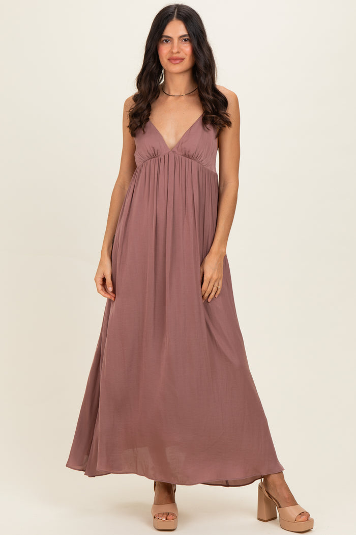 woman wearing a mauve sleeveless maxi dress with a deep v-neckline and flowy silhouette