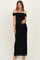 woman wearing a black off-shoulder maternity dress with a fitted silhouette and holding her baby bump