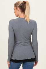 woman wearing a grey long sleeve maternity top with a scalloped hem, showing a fitted back view
