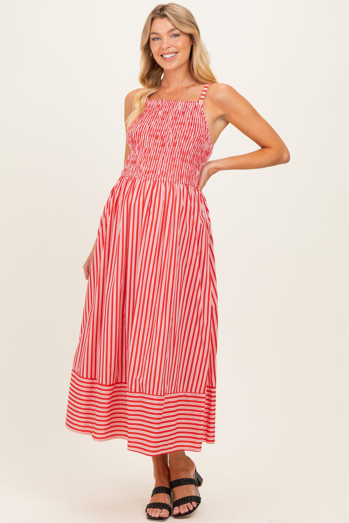 woman wearing a red and white striped maternity maxi dress with a smocked bodice and a flared skirt
