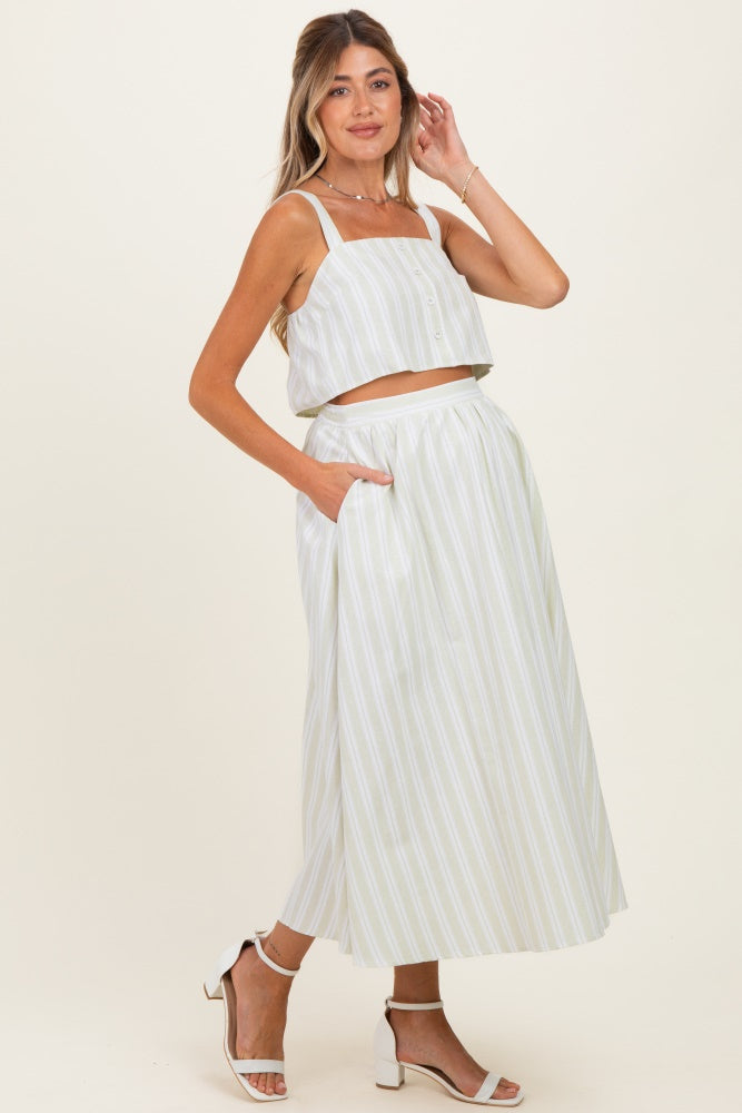 woman wearing a light green and white striped maternity crop top and matching maxi skirt with pockets