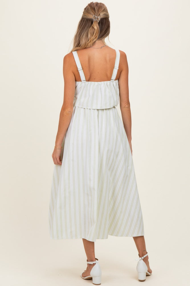 woman wearing a light green and white striped maternity dress with a ruffled bodice and open back