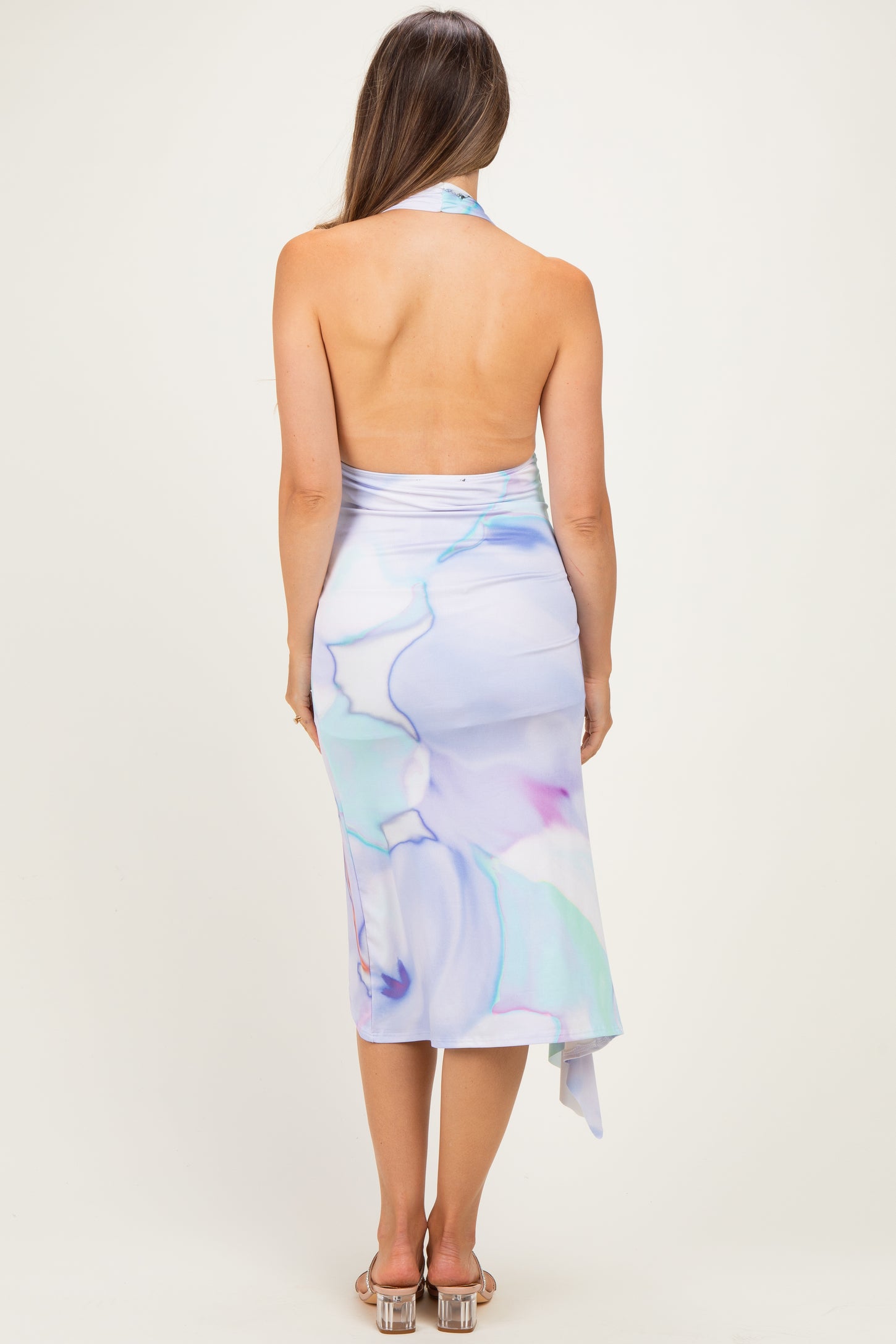 woman wearing a backless pastel abstract print maternity dress with a halter neck design