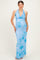 woman wearing a light blue floral halter maternity dress highlighting her baby bump