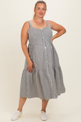 woman wearing a black and white striped maternity plus sundress with a tiered skirt and button details