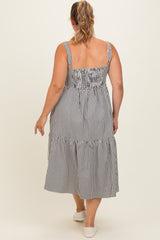 woman wearing a striped maternity plus dress with a smocked bodice and tiered skirt, showing the back view