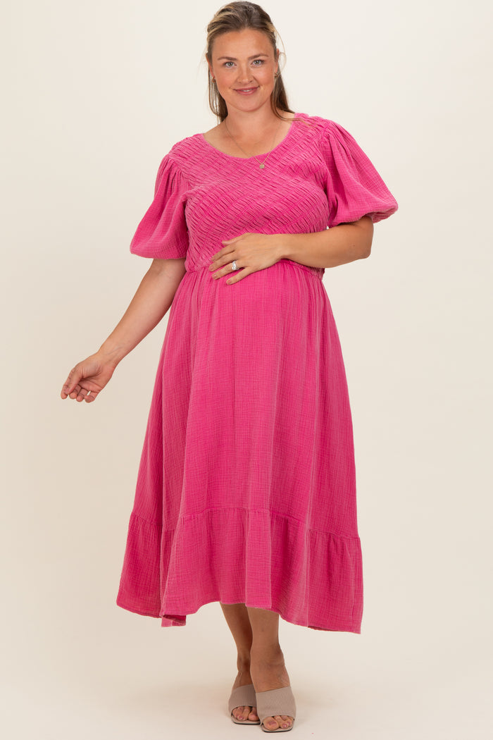 woman wearing a hot pink maternity plus dress with a smocked bodice and puff sleeves, showing her baby bump