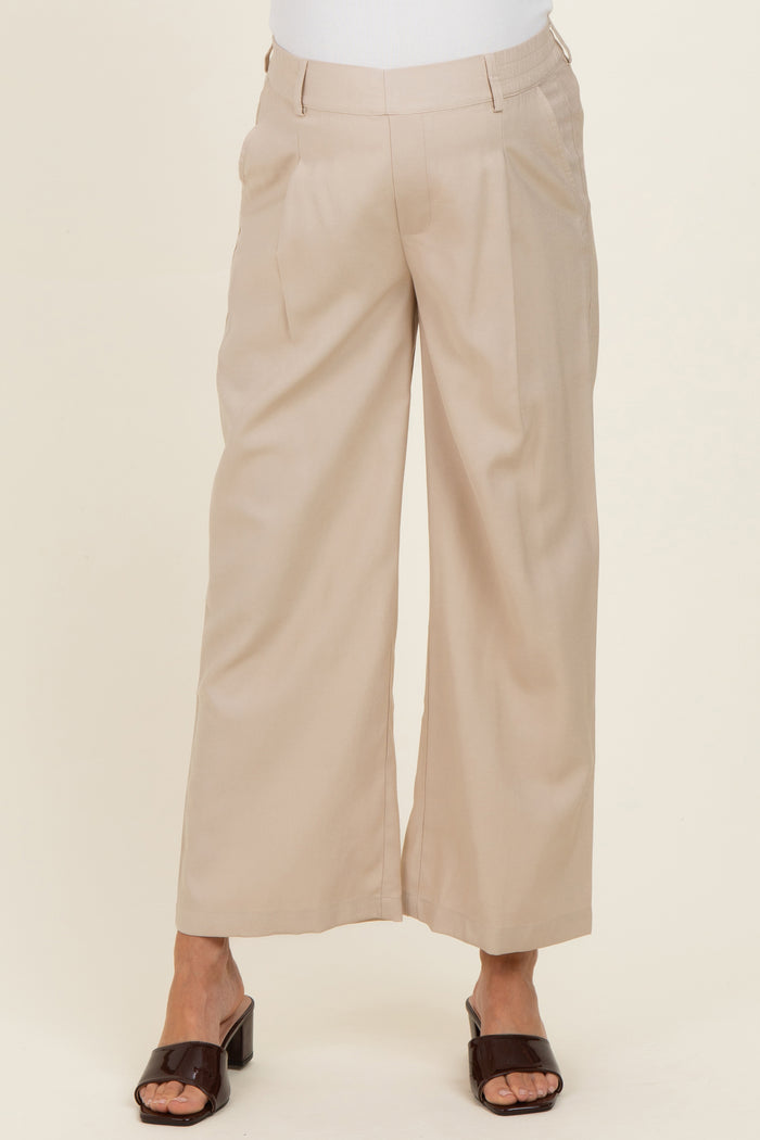 woman wearing beige wide leg maternity pants with a relaxed fit and side pockets