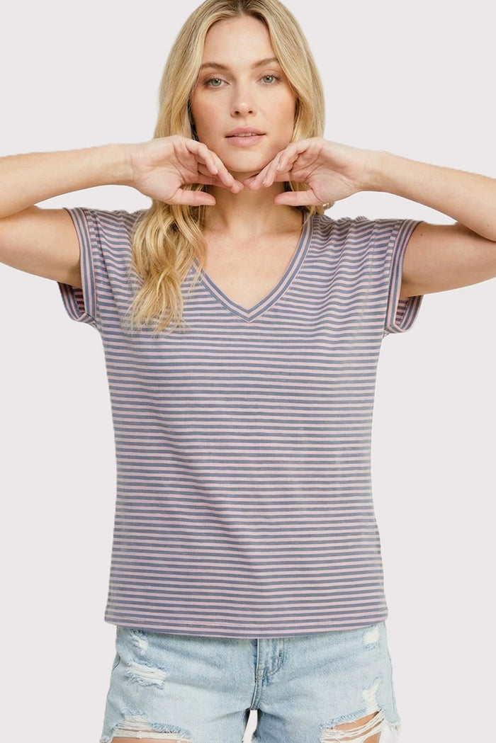 woman wearing a purple and white striped short sleeve v-neck t-shirt with a relaxed fit and distressed denim shorts