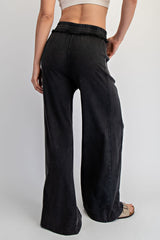 woman wearing black wide leg jeans with a smocked waist and a fitted top, seen from the back