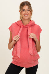woman wearing a coral sleeveless hoodie with a kangaroo pocket and drawstring ties, showcasing her baby bump