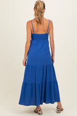 woman wearing a blue maternity maxi dress with a smocked bodice and tiered skirt, seen from the back