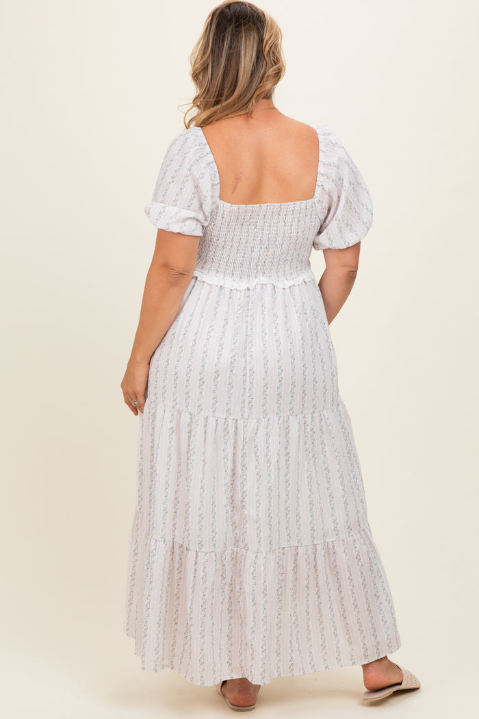 woman wearing a white floral smocked maternity maxi dress with puff sleeves, showing a relaxed fit on a baby bump