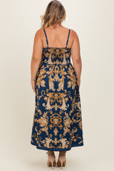 woman wearing a navy blue maternity plus maxi dress with a floral pattern and adjustable straps, viewed from the back